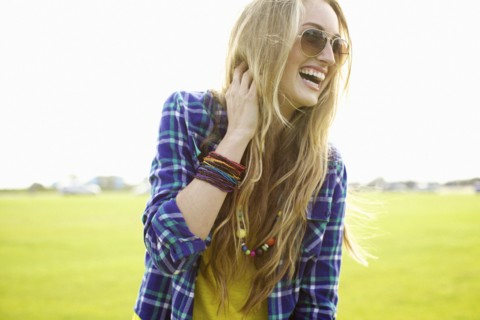 Laughing Caucasian woman standing in field