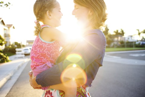 Mother holding daughter in street