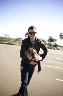 Father carrying daughter in parking lot