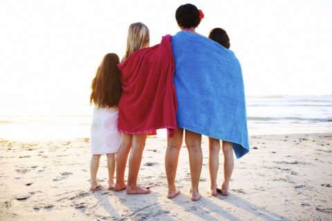 Girls wrapped in towels standing on beach