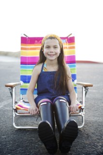 Mixed race girl sitting in lounge chair