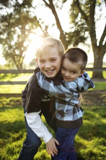 Caucasian brothers hugging outdoors