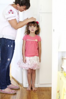 Mother measuring daughter's height