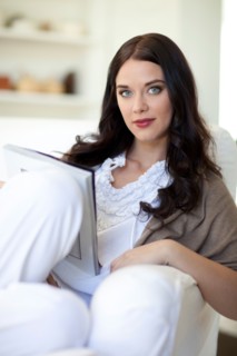 Woman sitting on sofa reading magazine