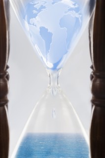 Globe squeezing through hour glass