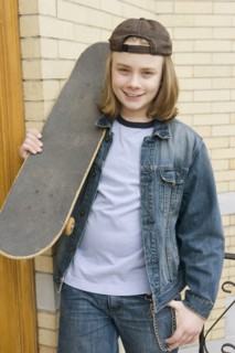 Caucasian boy standing with skateboard