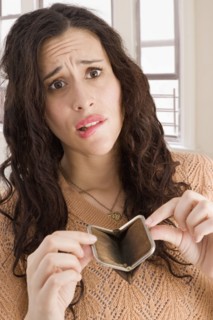 Mixed race woman opening empty coin purse
