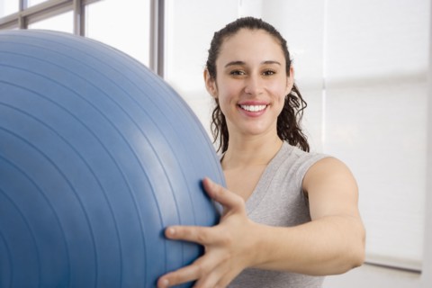 Mixed race woman holding large exercise ball