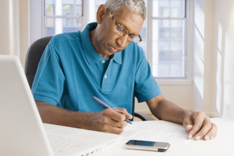 Mixed race man paying bills online