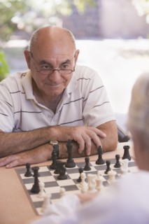 Senior men playing chess outdoors