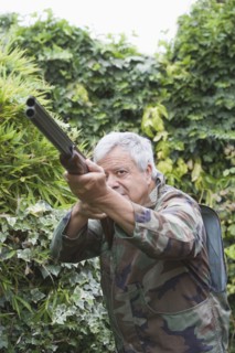 Senior Chilean man pointing shotgun
