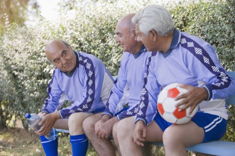 Senior Chilean soccer players sitting on bench