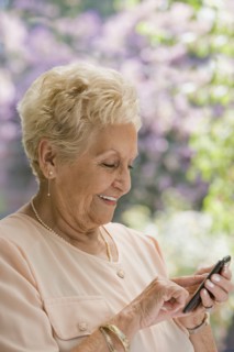 Senior Hispanic woman text messaging on cell phone