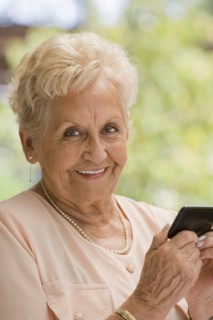 Senior Hispanic woman text messaging on cell phone