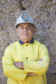 Hispanic miner in coat and hard-hat