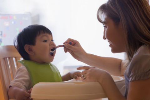 Hispanic mother feeding baby boy