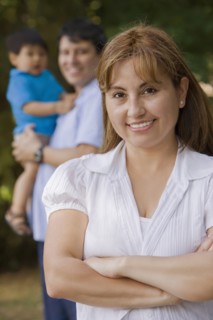 Smiling Hispanic woman outdoors with family