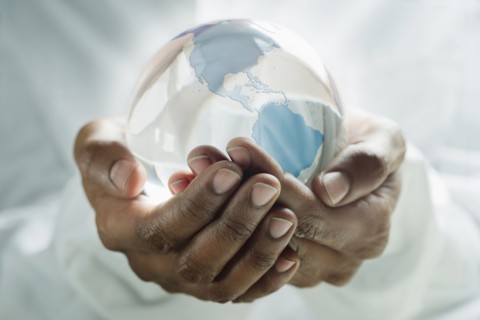 Mixed race man holding glass globe