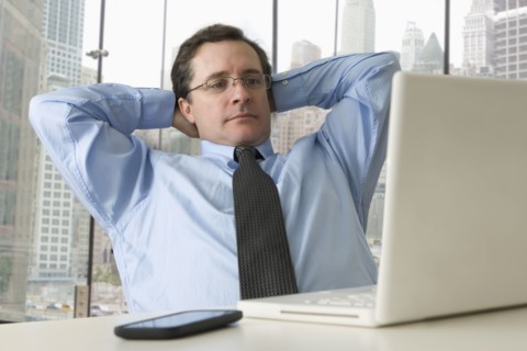 Serious Caucasian businessman with hands behind head