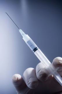 Close up of Hispanic doctor holding syringe
