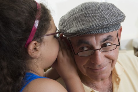 Hispanic girl whispering to grandfather