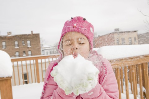 Hispanic girl playing with snowball