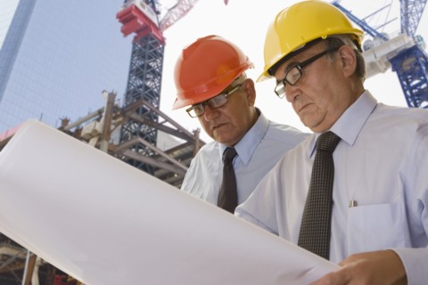 Hispanic businessmen reading blueprints
