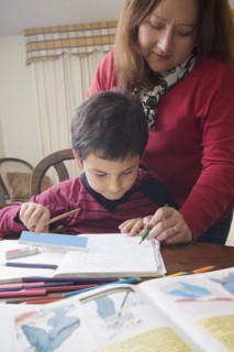 Hispanic mother helping son with homework