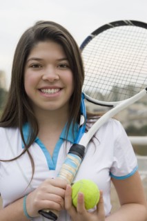 Hispanic girl playing tennis outdoors