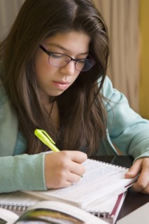Hispanic girl doing homework at table
