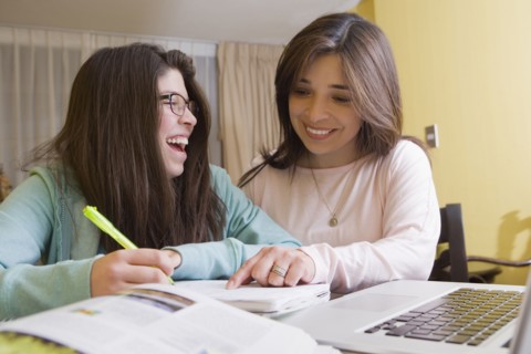 Hispanic mother helping daughter with homework
