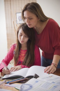 Hispanic mother helping daughter with homework