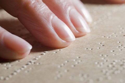 Close up of Hispanic woman reading Braille