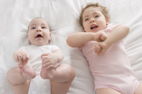 Hispanic babies laying on bed