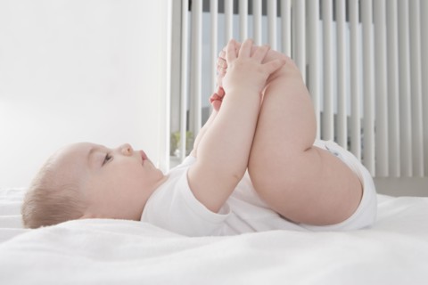 Hispanic baby boy playing with feet