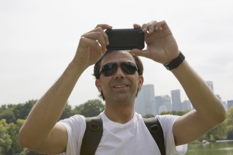 Hispanic man using camera phone
