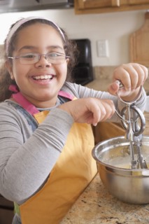 Portrait of smiling Hispanic girl baking in kitchen