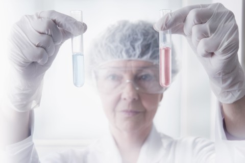 Hispanic scientist examining test tubes in lab