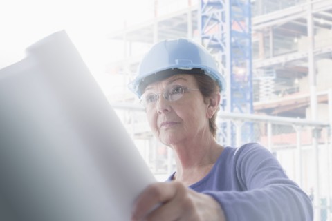 Hispanic architect reading blueprints