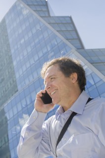 Hispanic businessman talking on cell phone on city street