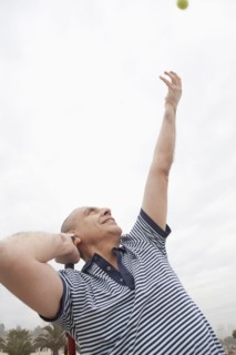 Hispanic senior man playing tennis outdoors