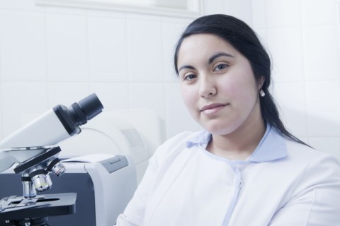 Hispanic scientist smiling in laboratory