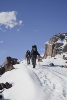 Hispanic hikers walking on snowy mountain