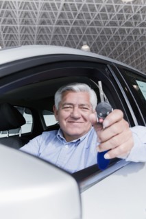 Hispanic man holding keys to new car