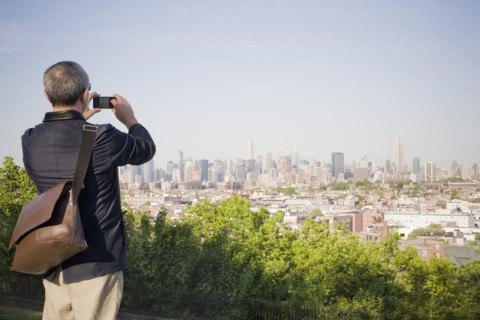 Hispanic man photographing New York cityscape