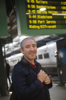 Hispanic man standing on platform in train station