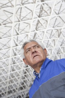 Low angle view of older Hispanic mechanic in warehouse