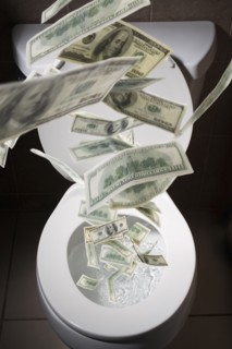 Dollar bills falling into toilet