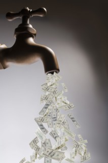 Dollar bills pouring out of faucet