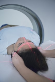 Hispanic nurse examining patient in MRI machine